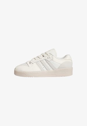 White leather sneakers with perforated toe, three grey stripes on the side, and a translucent rubber sole. Features rounded toe and lace-up design.