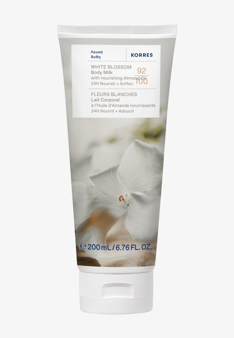 Valkoinen Kukka -vartalovoide 200 ml valkoisessa tuubissa. Ominaisuuksina pehmeä koostumus ja kukkakuvio, jossa on valkoisen kukan kuva ja sinistä tekstiä.