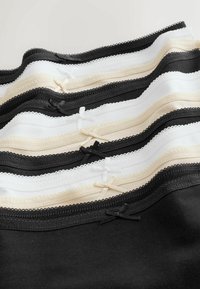 Różnorodne elastyczne koszulki na ramiączkach wykończone koronką w kolorach czarnym, białym i beżowym, ozdobione kokardkami i wykonane z miękkiej bawełny dla komfortu.