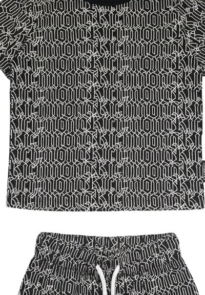 Completo con maglietta a maniche corte e pantaloncini in bianco e nero con motivo ripetuto di testo stilizzato in bianco.