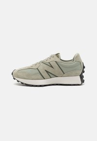 Green suede and mesh sneaker with a rounded toe, black rubber outsole, and prominent "N" logo. Designed for comfort and style.