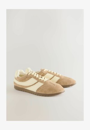 Bruna sneakers i mocka med krämfärgade ränder och snören, med ett mjukt inre foder och ett texturerat yttersula. Klassisk retrodesign.