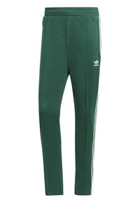 Green athletic pants with a textured finish, featuring side zip pockets, white stripes along the sides, and a small white logo on the thigh.