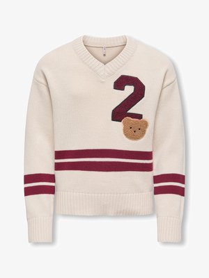 Pull en maille crème avec un numéro 2 bordeaux et un patch ourson, présentant deux bandes horizontales bordeaux sur les manches et le torse.