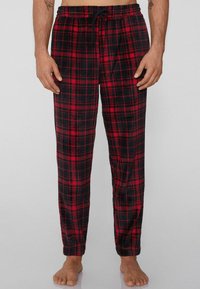 Červené a černé kárované flísové py�žamové kalhoty s elastickým pasem a šňůrkou, s volným střihem a jednobarevnými manžetami.