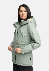 Light green, hooded jacket with a fur lining, zip closure, two front pockets, toggle adjustments at the waist, and embroidered logo on sleeve.