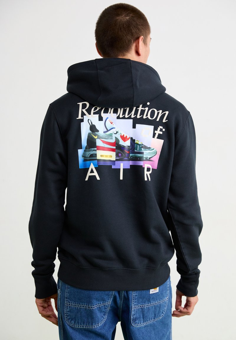 Sort hoodie med farverige sneakers graphics på ryggen, med teksten "Revolution of AIR" i lys skrift og ribbede mansjetter og kant.