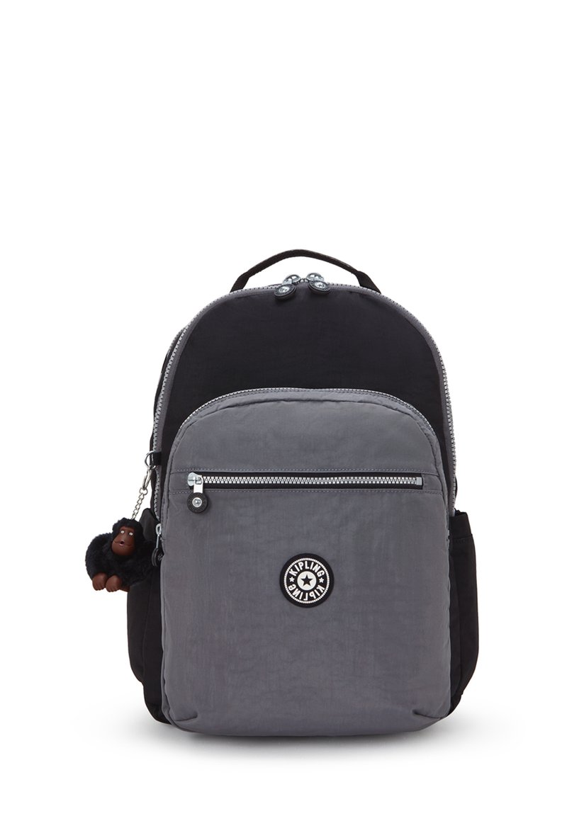 Grau-schwarzer Nylon-Rucksack mit zwei Reißverschlussfächern, ausgestattet mit einem Logo-Patch und einem kleinen Affen-Schlüsselanhänger.