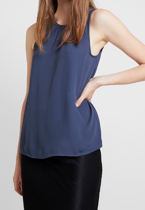 Marineblaue ärmellose Bluse mit rundem Halsausschnitt und fließendem Stoff. Sie zeichnet sich durch eine glatte Textur und dezente Raffung am Halsausschnitt aus.
