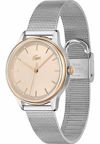 Sølv mesh remmeklokke med en rund, rosagull-tone bezel og en minimalistisk beige skive, med time markører og en liten logo.
