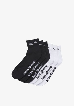 Tre paia di calzini alla caviglia neri e tre paia bianchi con la scritta "KARL KANI" e il logo sul lato e un ricamo vicino al bordo.