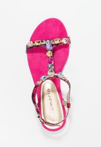 Světlé růžové dámské sandály s T-páskem zdobené velkými multikolorovými kameny a páskem s hadí vzorem s přezkou.