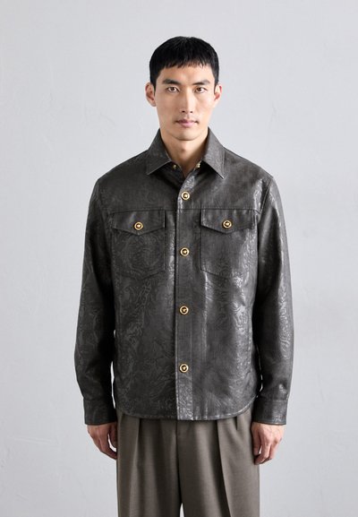 Dark gray textured jacket with a floral pattern, featuring gold buttons, a collared neckline, and two chest pockets.
