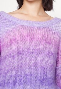 Lila Farbverlauf-Pullover mit schulterfreiem Ausschnitt. Hergestellt aus weichem, strukturiertem Garn, mit lockerer Passform und gerippten Kanten.