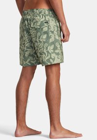 Pantaloni da bagno verdi con motivo a foglie bianche, vita elastica, tasca posteriore e vestibilità comoda, realizzati in tessuto leggero.