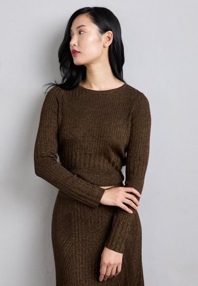 Top din tricot ribat maro, cu maneci lungi, guler rotund și siluetă ajustată, care completează o fustă asortată, având detalii texturate subtile.