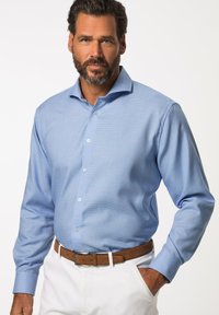 Světle modrá dlouhá košile s knoflíky a jemným vzorem, s rozhalenkou a bílými knoflíky, v kombinaci s bílými kalhotami a hnědým opaskem.