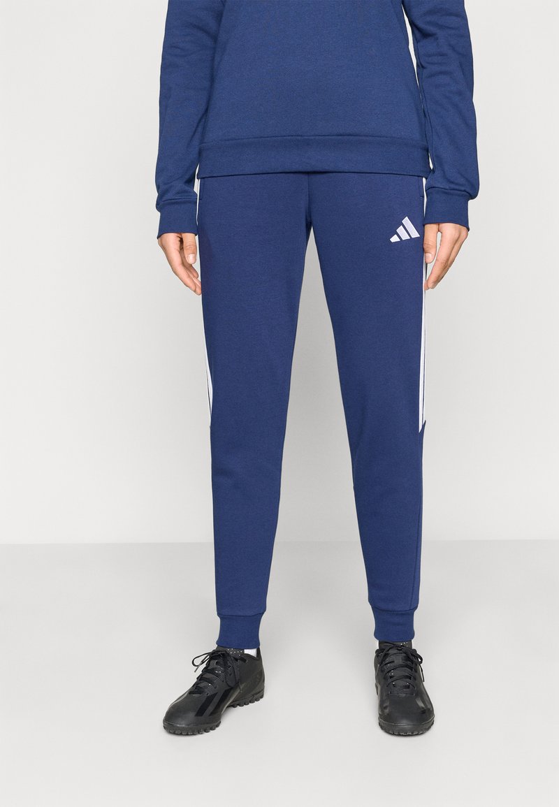 Μπλε ναυτικό αθλητικό παντελόνι jogger με λευκές λωρίδες στο πλάι και λογότυπο Adidas. Κατασκευασμένο από μαλακό υλικό, με εφαρμογή που στενεύει προς τα κάτω και ριμπ μανσέτες.