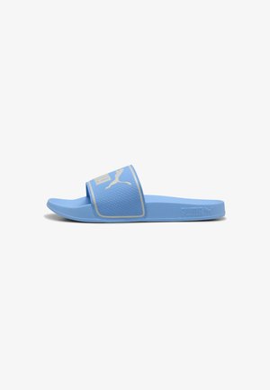 Sandały slip-on Puma w jasnoniebieskim kolorze z teksturowanym paskiem, z logo i kontrastującymi akcentami. Płaska, gumowa podeszwa, idealna do codziennego noszenia.