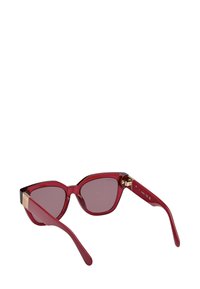 Röda katteye solglasögon med mörka linser och guldaccenter på bågarna, visade från en vinklad bakvy på en vit bakgrund.