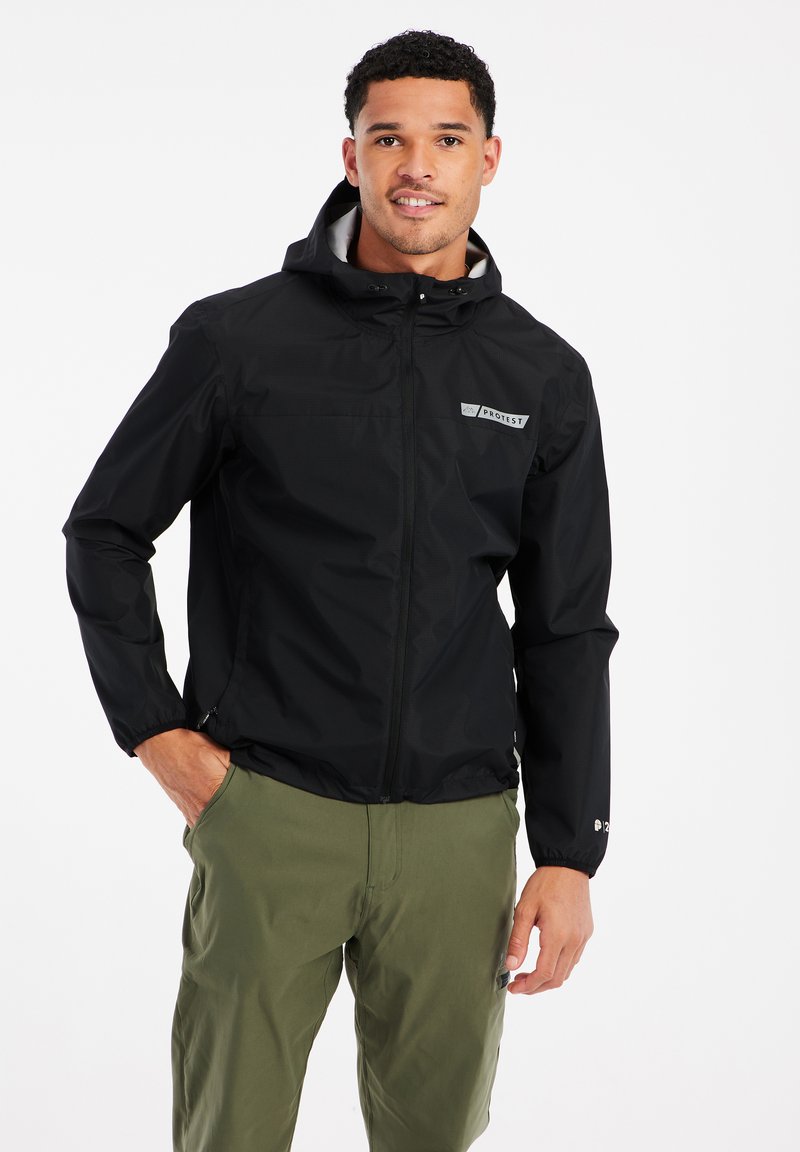 Czarna, lekka kurtka z pełnym zamkiem błyskawicznym i kapturem, z szarym logo naszytym na piersi. Gładka tekstura i elastyczne mankiety.