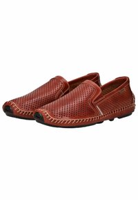 Zapatos slip-on de cuero perforado marrón con costuras en tono marrón claro, punta redondeada y suela de goma negra. Presentan un diseño casual y material transpirable.