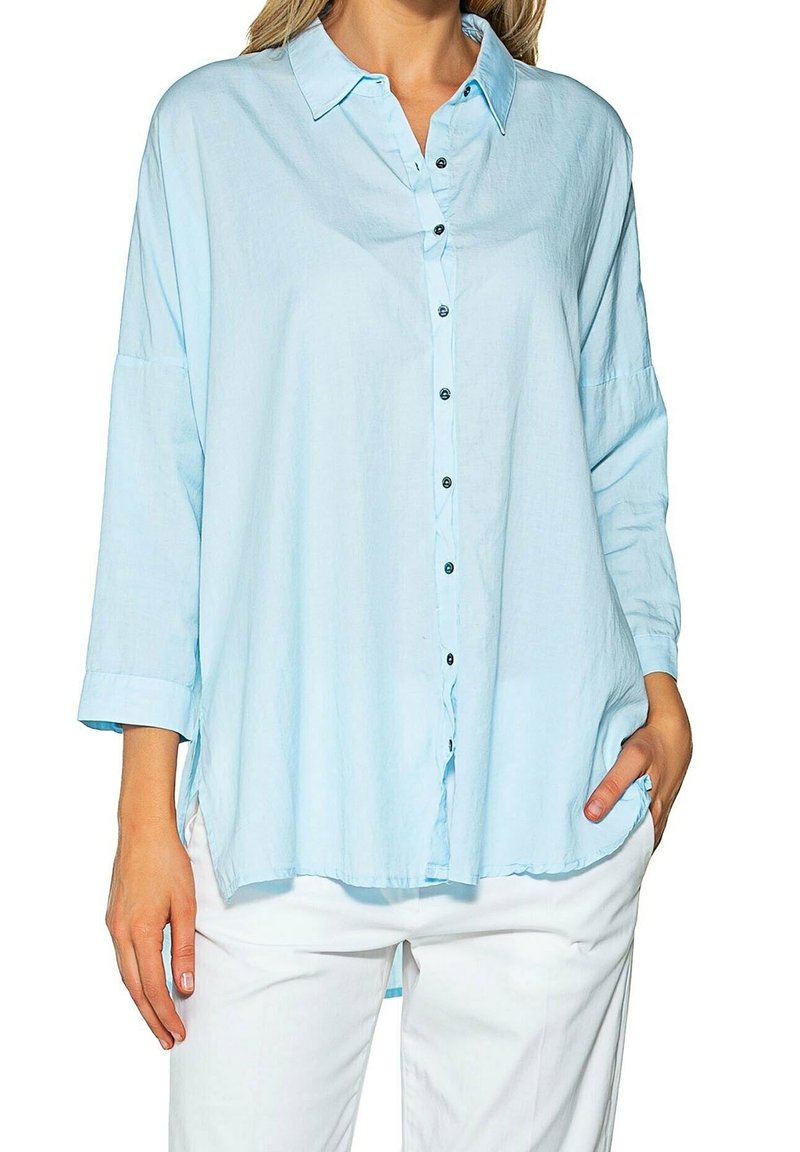 Light blue, long-sleeve button-up shirt, featuring a collared neckline, black buttons, and loose fit with side slits at the hem.