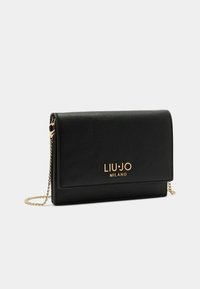 Clutch bag in pelle nera con tracolla a catena dorata. Presenta una patta pieghevole e un logo impresso sul davanti. Superficie strutturata.