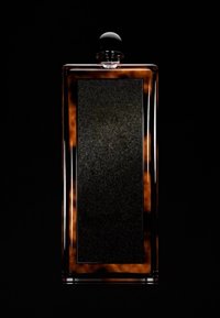 Square glass perfume bottle with a tortoiseshell pattern, matte black label, and a round black cap. The texture is smooth and glossy.