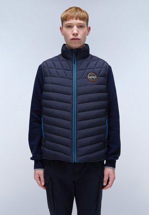 Marineblauw gewatteerd vest met een quilted ontwerp en blauwe ritsaccenten. Heeft een hoge kraag en een logo patch op de borst.