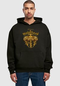 Felpa nera in cotone, con una grafica centrale dorata che presenta il logo Motorhead e teschi, tasca a marsupio e polsini a coste.