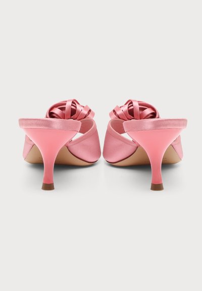 Paire de mules à talons hauts en satin rose avec dos ouvert et nœuds torsadés sur les brides, vues de dos sur fond blanc.