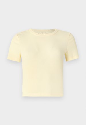 T-shirt à manches courtes côtelé de couleur jaune pastel doux. Il présente un col rond et un ourlet droit. Confectionné dans un tissu lisse et extensible.