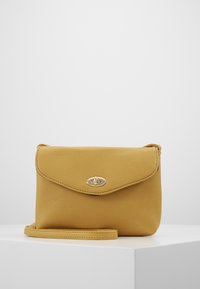 Żółta skórzana torba na ramię z teksturowaną powierzchnią, klapką zamykającą i złotymi akcentami metalowymi. Zawiera odpinany pasek.