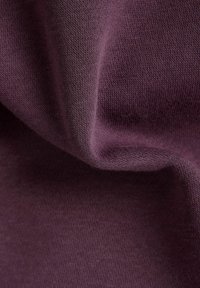 Purple knit fabric with a soft texture, showing a smooth surface and slight draping. The pattern is plain without visible embellishments.