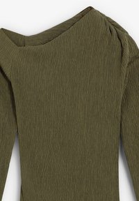 Olivgrön texturerad långärmad topp med puffiga axlar och en lätt rynkad sömdetalj nära halsen.