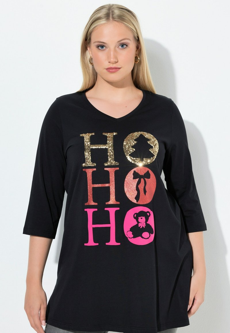 Svart tunika med trekvartsärmar som har metallisk och glittrig "HO HO HO" text i guld, rosa och pink. Mjuk bomullsmaterial.