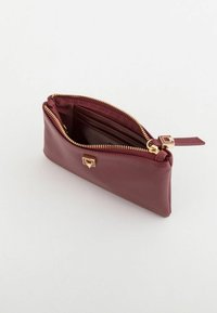 Viininpunainen vetoketjullinen lompakko, jossa on teksturoitu ulkopinta, kultasävyiset metalliosat, ohut muotoilu ja useita korttipaikkoja sisällä.