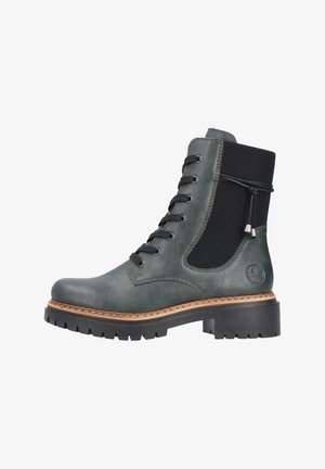 Stivale alla caviglia verde in pelle con un pannello in rete nera testurizzata, allacciatura frontale, suola in gomma spessa e dettagli di cucitura a contrasto in color tan.