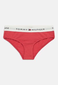 Crvene pamučne gaće s bijelim pojasom na kojem je ispisano "TOMMY HILFIGER" u crnoj i sivoj boji, glatke teksture i klasičnog kroja.