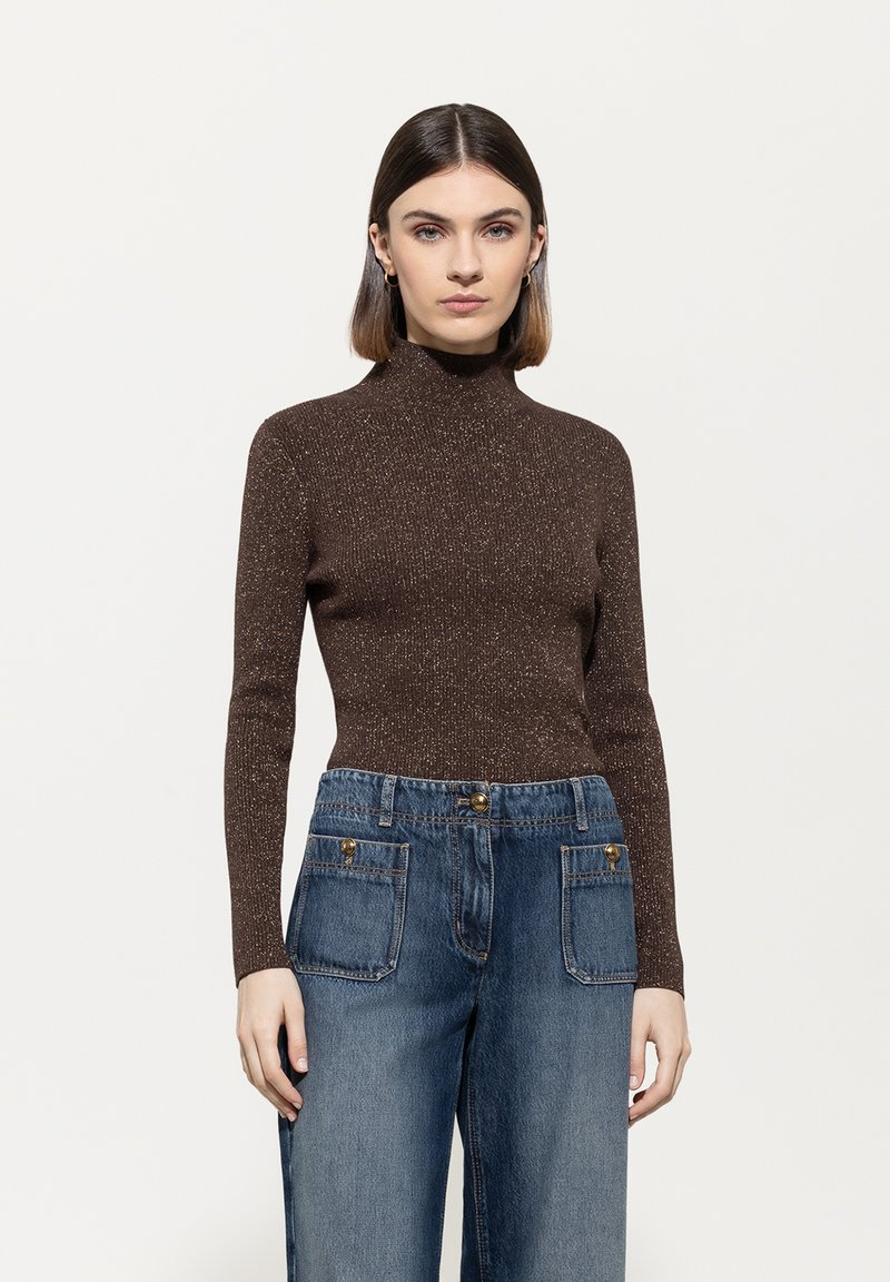 Braunes, langärmliges Rollkragensweatshirt mit einem subtilen Glanz, kombiniert mit weiten blauen Denim-Jeans mit Fronttaschen und Knopfakzenten.