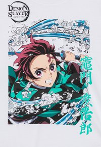 White t-shirt featuring a graphic of a character wielding a sword, adorned with bold colors, green and black patterns, and swirling cloud designs.