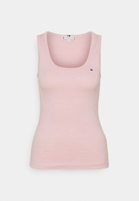 Top in cotone rosa a coste con scollatura a girocollo e spalline larghe. Presenta un piccolo logo sulla parte sinistra del petto. Materiale morbido e elastico.