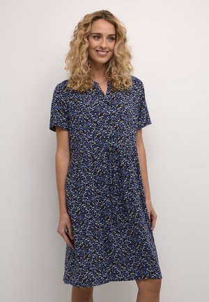 Blaue Blumenkleid mit kurzen Ärmeln, das einen kragenlosen Ausschnitt, eine Knopfleiste und eine lockere Passform aufweist. Das Muster beinhaltet weiße und gelbe Akzente.