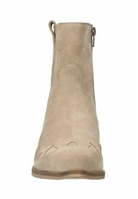 Stivale alla caviglia in suede beige con texture liscia, punta affusolata, dettagli a intaglio sul davanti e zip laterale per la chiusura.