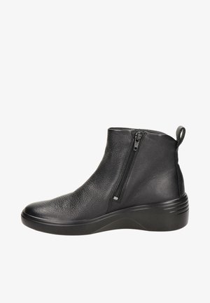 Bottine en cuir noir avec fermeture éclair latérale, tige texturée, languette de traction au talon et semelle légèrement surélevée et rembourrée.