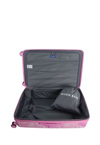 Rosa Koffer mit hartem Schalenmaterial, das Innere mit einer Reißverschlusstasche unterteilt, beinhaltet eine schwarze Toilettentasche mit der Aufschrift "WASCHTASCHE". Weiche Textur, glatte Oberfläche.