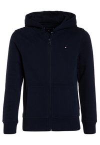 Marinblå zip-up huvtröja, tillverkad av mjukt tyg, har en huva med dragsko, framfickor och ribbade mudd för en bekväm passform.