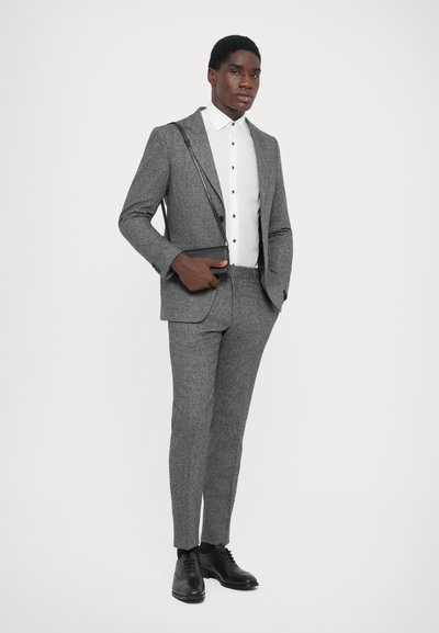 Grau strukturiertes Anzug mit einem weißen Hemd und schwarzen Schuhen. Der Anzug hat ein tailliertes Design und einen leichten Glanz, mit vorderen Taschen.