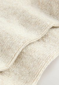 Beige knitted fabric with a soft, textured surface; characteristic loose weave, subtle variations in color, and neatly finished edges.